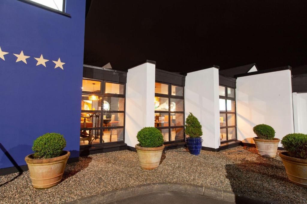 um edifício com estrelas na parede e vasos de plantas em Best Western Plus White Horse Hotel em Derry Londonderry