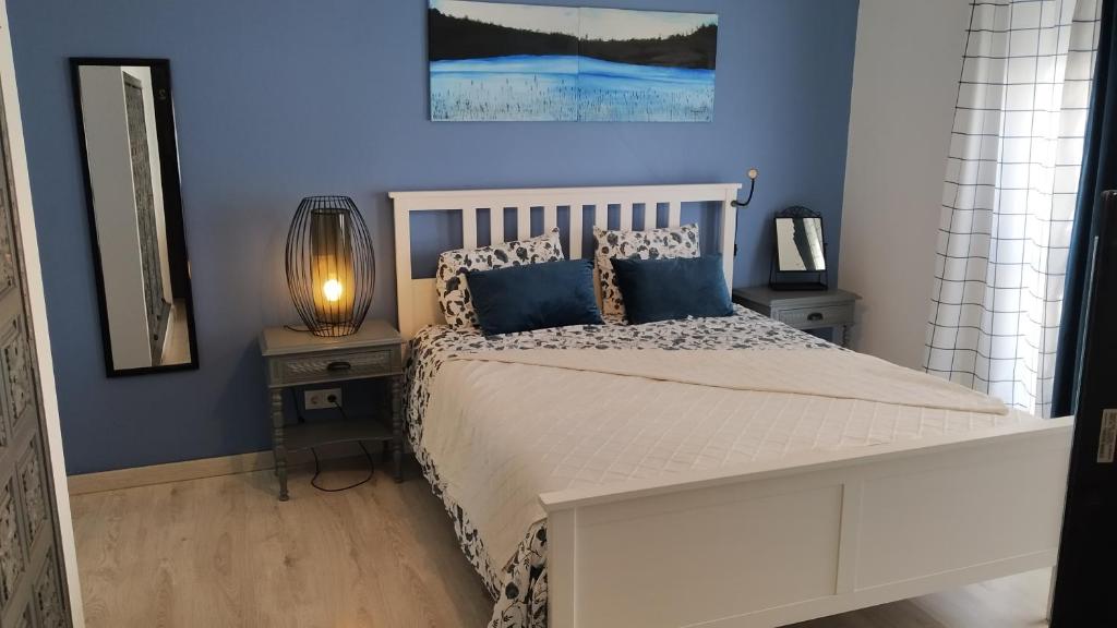 1 dormitorio con 1 cama blanca y paredes azules en Forever São Brás, en São Brás de Alportel