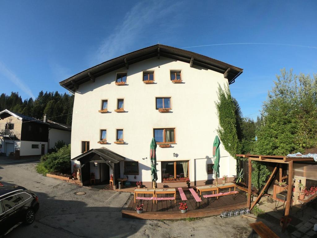 a large white building with a group of tables at Pension Tyrol in Maria Alm am Steinernen Meer