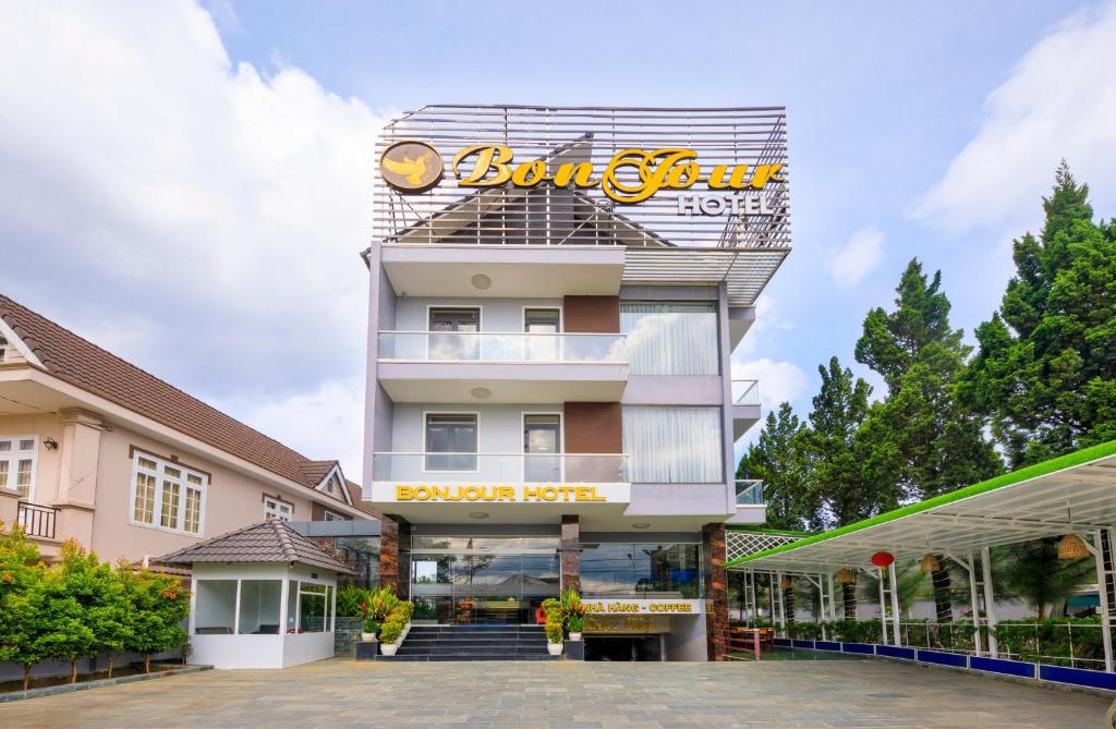 un edificio con un cartel en la parte delantera en Bonjour Da Lat Hotel, en Da Lat