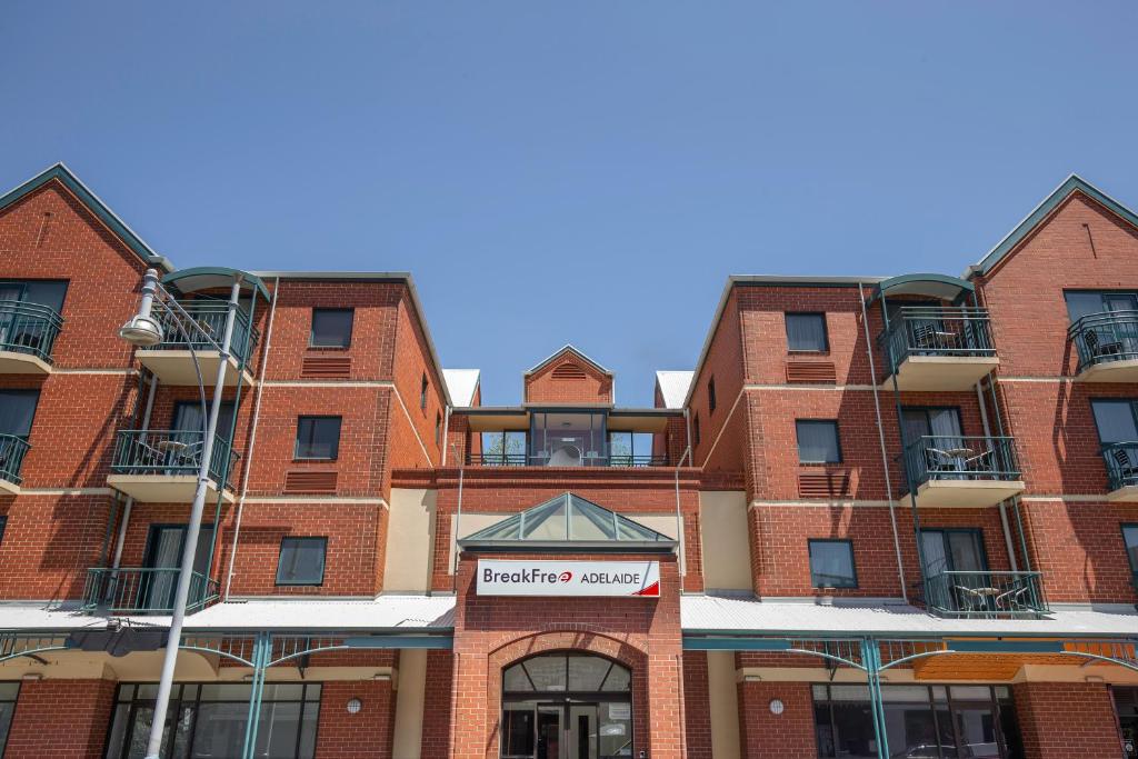 un edificio de ladrillo rojo con un cartel. en BreakFree Adelaide en Adelaida