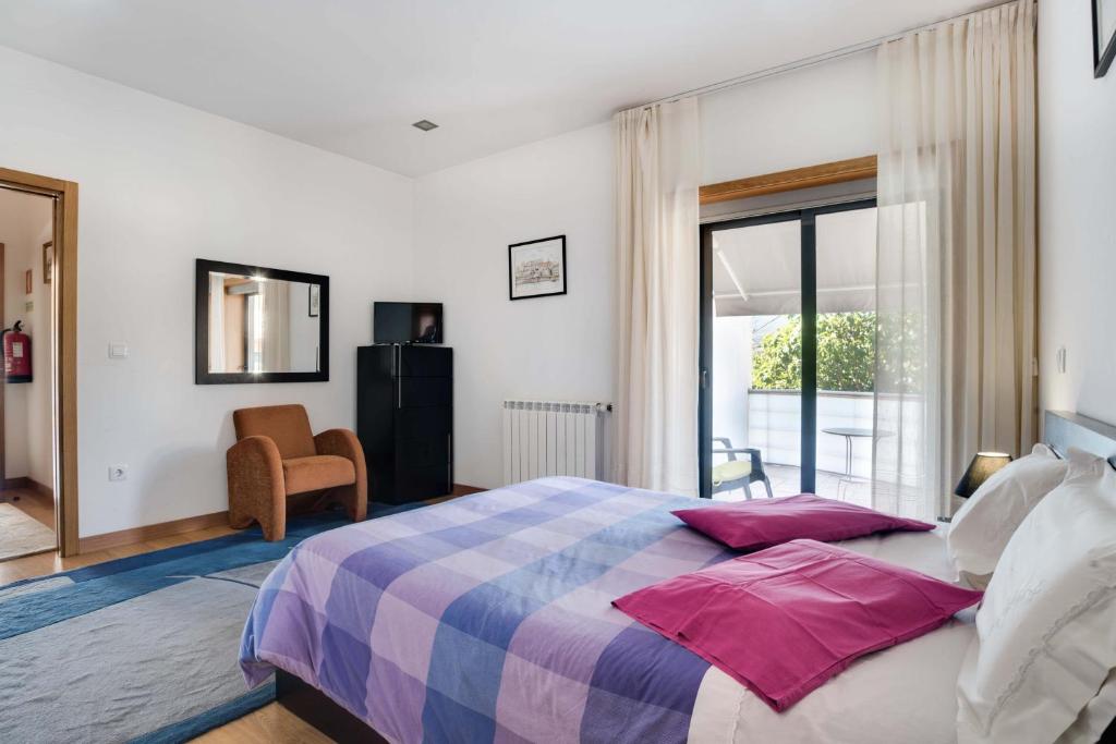 a bedroom with a large bed with pink pillows at Casa de Coelhosa in Vale de Cambra