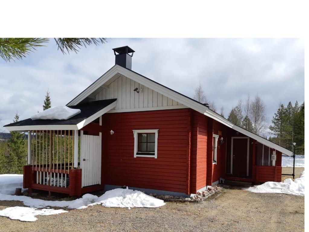Kotila的住宿－Metsorinne 3A sarvipöllö，一座红色的小建筑,地面上积雪