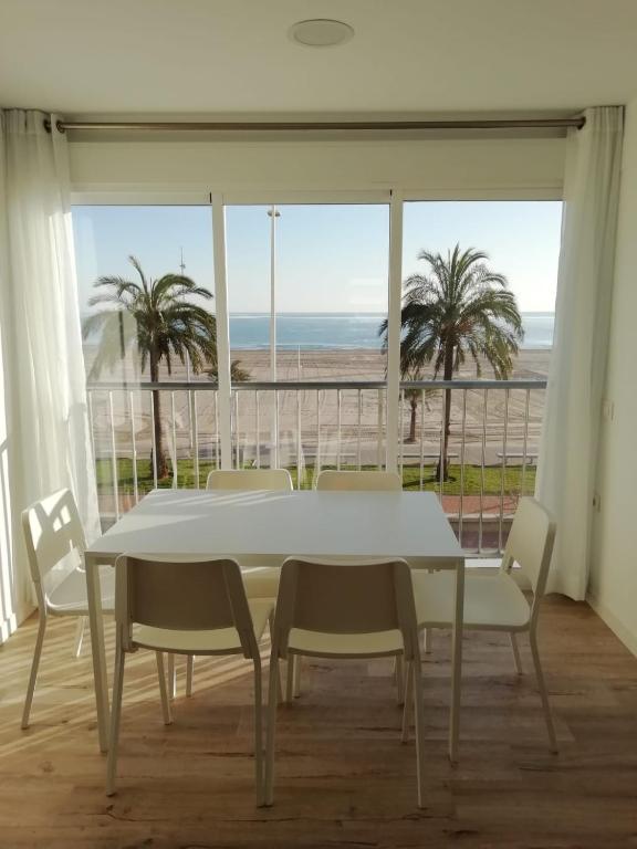 Biały stół i krzesła z widokiem na ocean w obiekcie Infante II Primera Linea Playa De Gandia SOLO FAMILIAS w mieście Playa de Gandia
