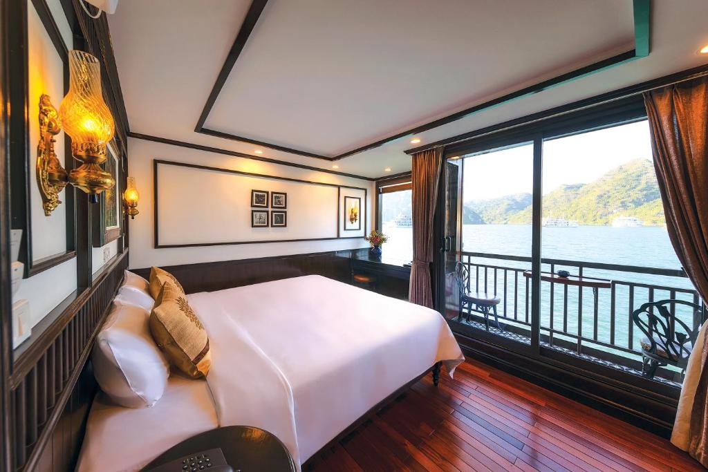 a bedroom with a bed and a balcony at Sena Cruises - Wonder On Lan Ha Bay in Ha Long
