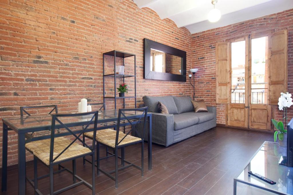 a living room with a couch and a brick wall at Modern 2-bedroom apartment near Sagrada Familia in Barcelona