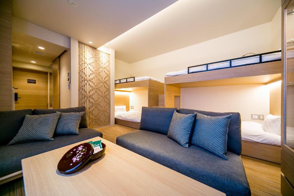 a living room with a couch and two bunk beds at ORI Kyoto in Kyoto