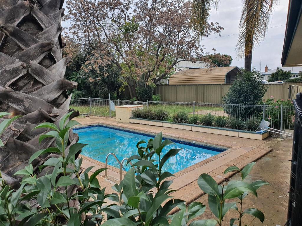 una piscina en un patio con una valla en The Aston Motel Tamworth, en Tamworth
