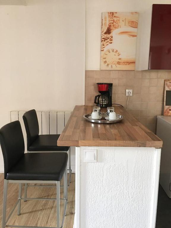 une cuisine avec un comptoir, une table et des chaises dans l'établissement Appartement 4 couchages , équipé de la fibre, à Briare