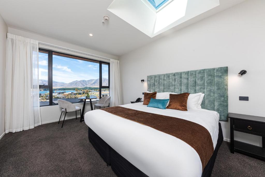 1 dormitorio con cama grande y ventana grande en Galaxy Boutique Hotel, en Lake Tekapo