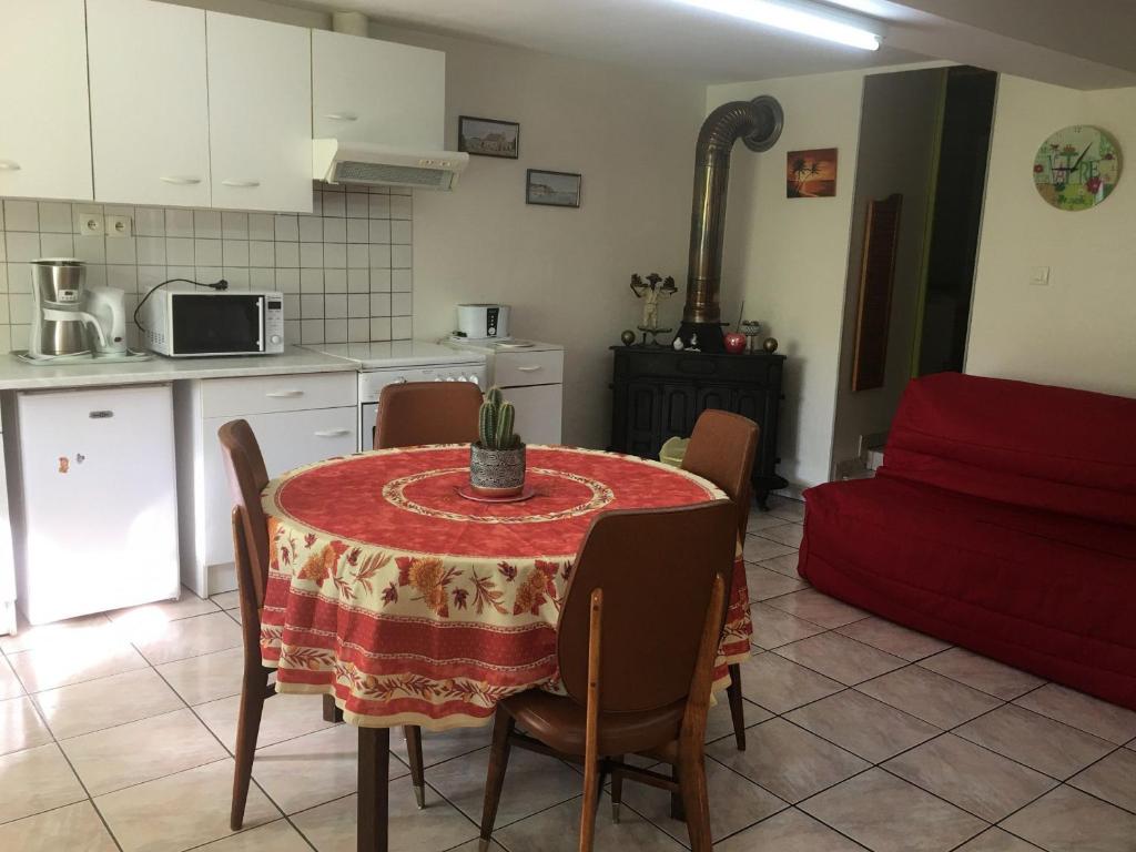 una cocina y una mesa con un mantel rojo. en Gîte Rozelieures, 2 pièces, 2 personnes - FR-1-584-59 