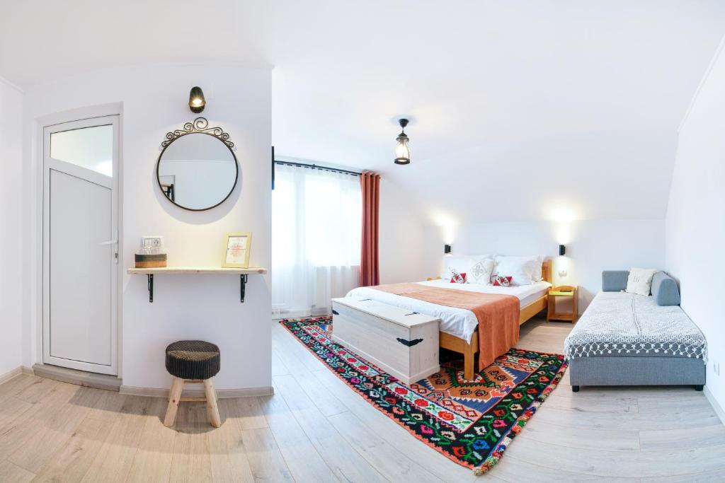 a bedroom with a bed and a mirror and a rug at Casa Elia in Bran
