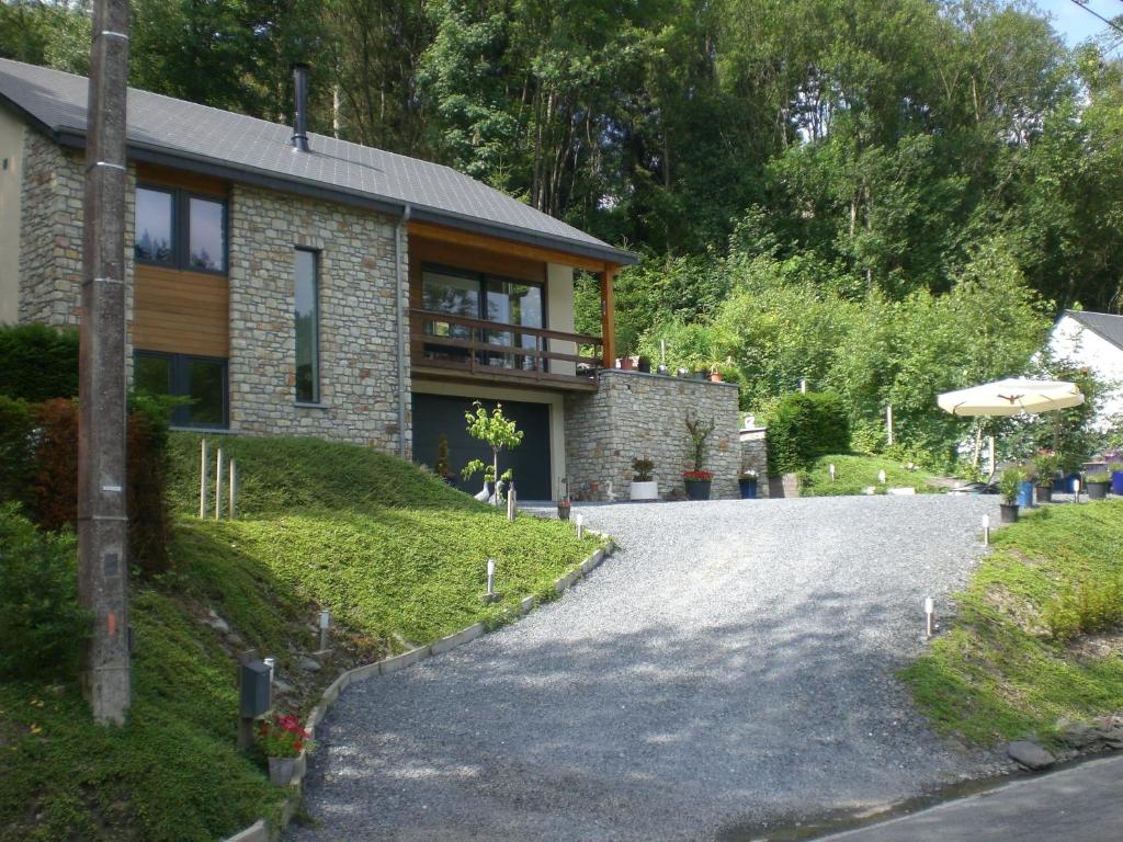 una casa de ladrillo con entrada y sombrilla en B&B L'ourthe, en Houffalize