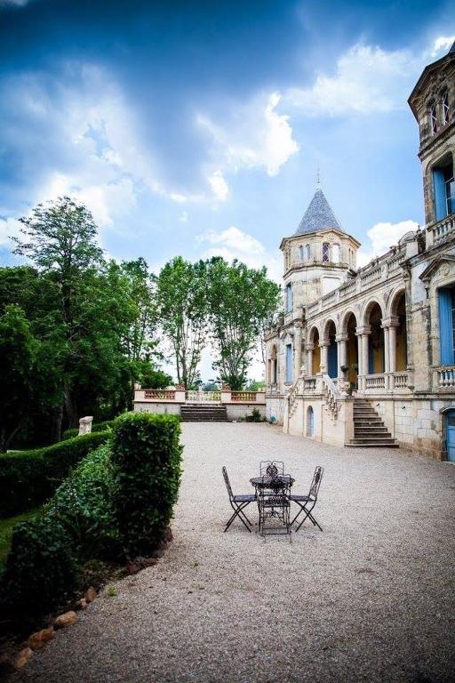 une table et des chaises devant un bâtiment dans l'établissement Château Sainte cécile Chambres D'hôtes / Guest house in Castle Château sainte cécile, à Nézignan-lʼÉvêque