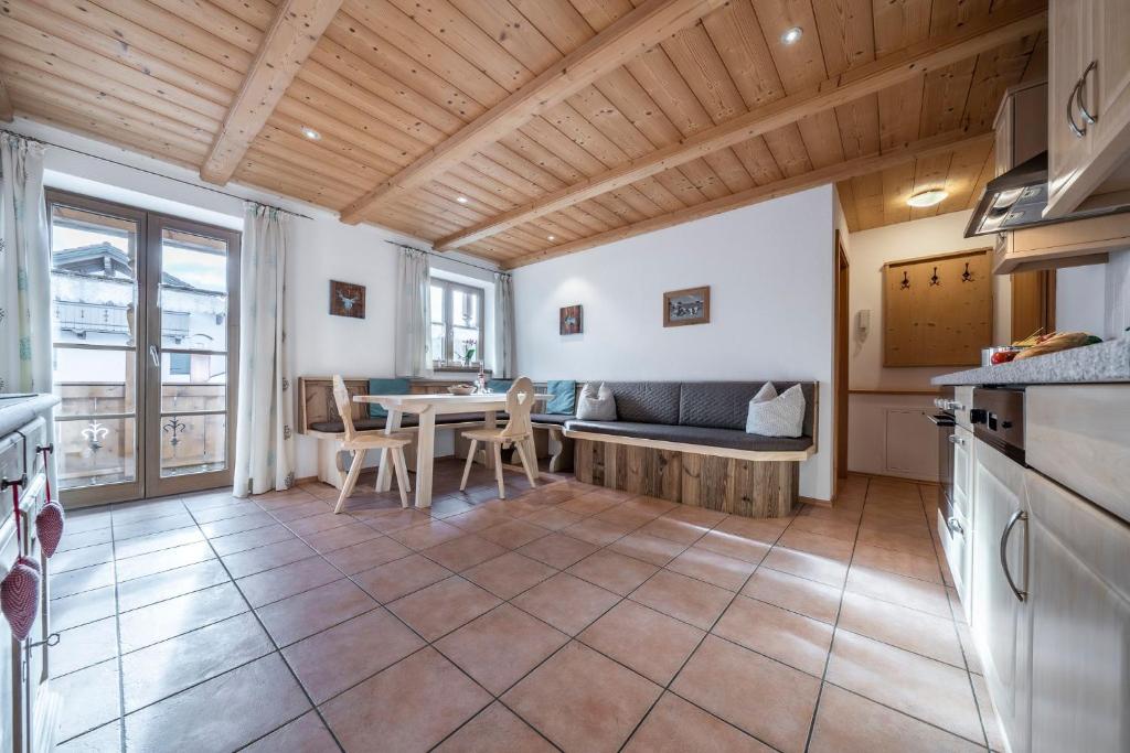 a kitchen and living room with a table and a couch at Ferienwohnungen am Lahnerbach in Lenggries