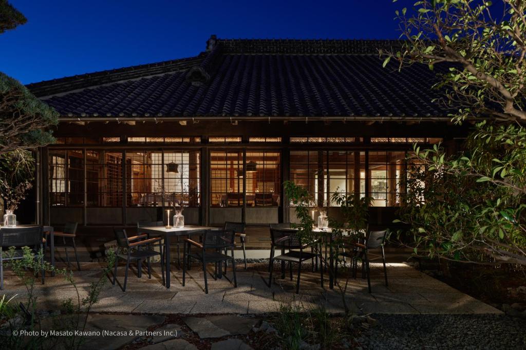 un patio con mesa y sillas frente a una casa en LOQUAT西伊豆 en Izu