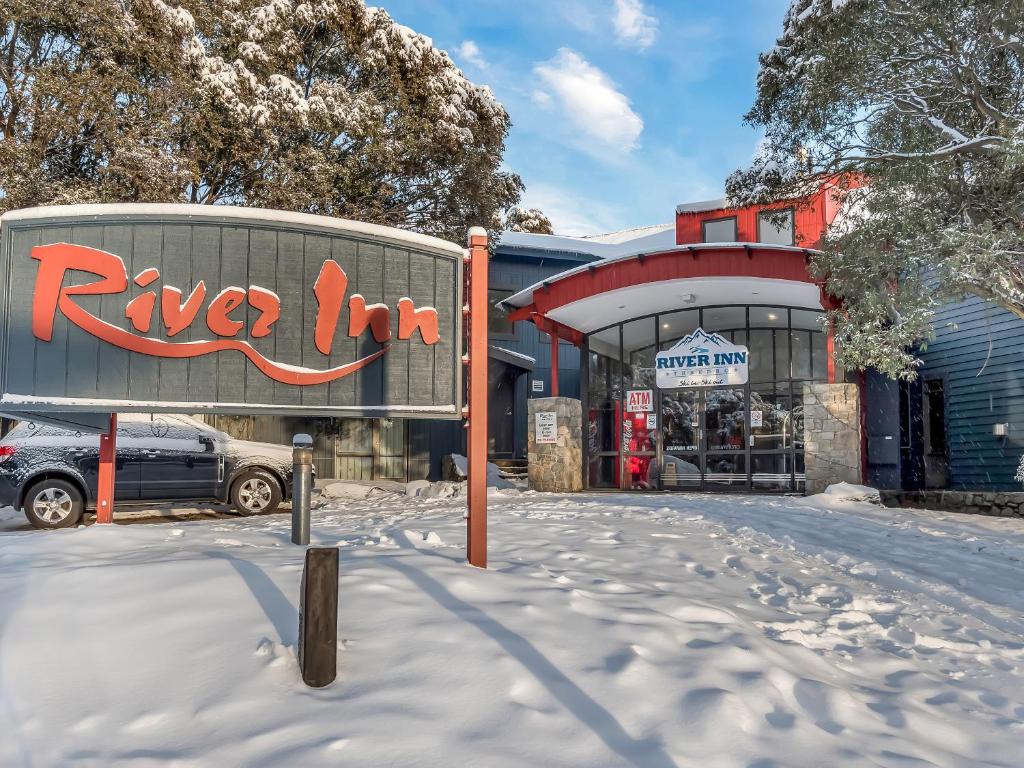 a building with aryan inn in the snow at The River Inn Thredbo in Thredbo
