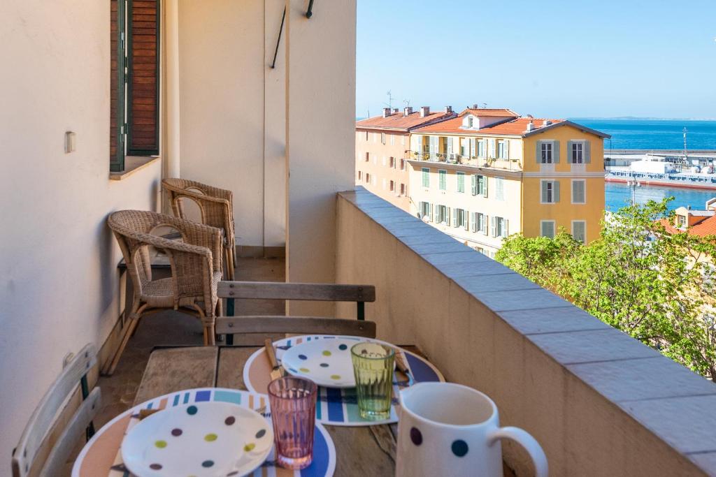d'un balcon avec deux tables et une vue sur l'eau. dans l'établissement Le Lympia, à Nice