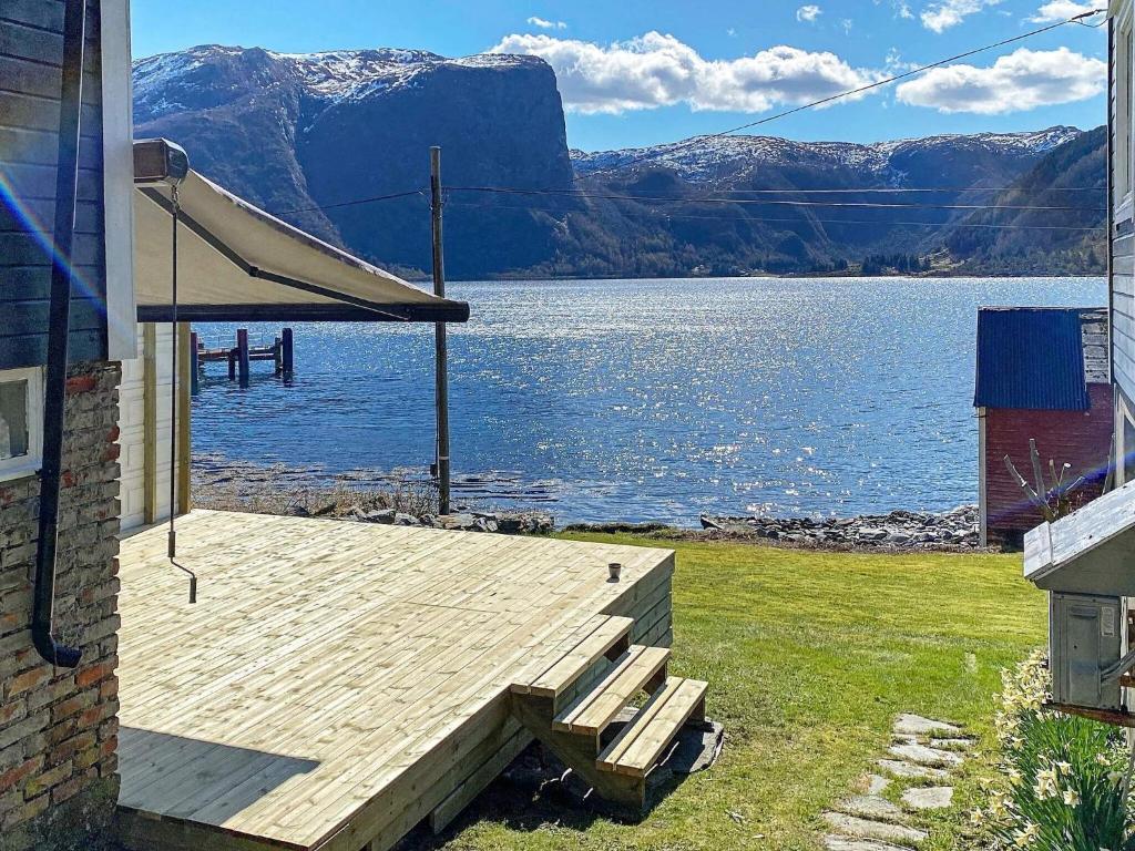 uma casa com um deque de madeira ao lado de uma massa de água em 8 person holiday home in Barmen em Barmen