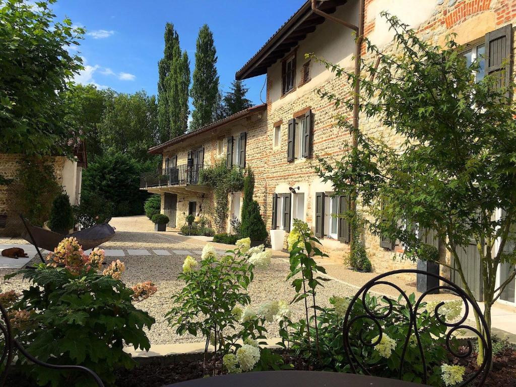 un jardin en face d'un bâtiment dans l'établissement LE MOULIN DE LONGCHAMP - Maison d'Hôtes, à Lent