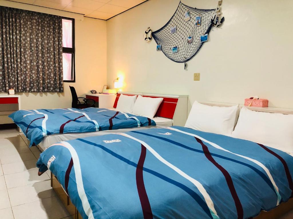 1 Schlafzimmer mit 2 Betten mit blauer und weißer Bettwäsche in der Unterkunft 暖暖 158 旅宿 in Taitung