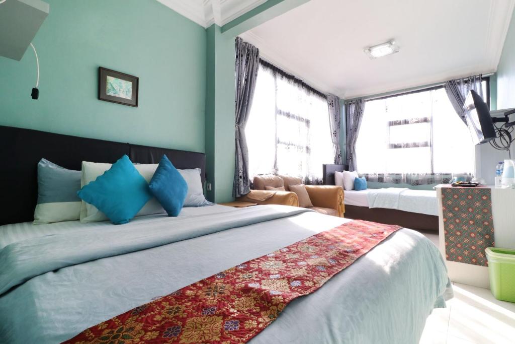 Cet appartement comprend une chambre dotée d'un grand lit, de murs bleus et de fenêtres. dans l'établissement Lembur Incu Syariah Villa & Resto, à Lembang