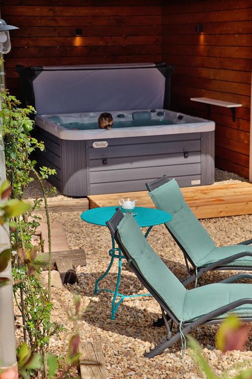 a patio with two chairs and a hot tub at Mustármag Vendégház in Noszvaj