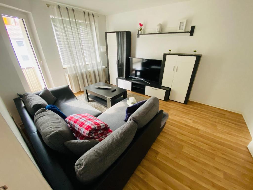a living room with a couch and a television at Near Tram l 3 Beds l 2 Sleeping Room l Own Parking Space in Bielefeld