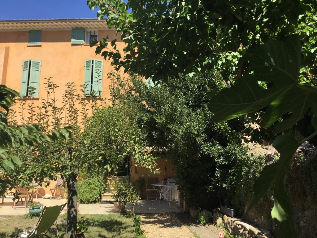 an orange building with trees in front of it at Les Lauriers in Camps-la-Source