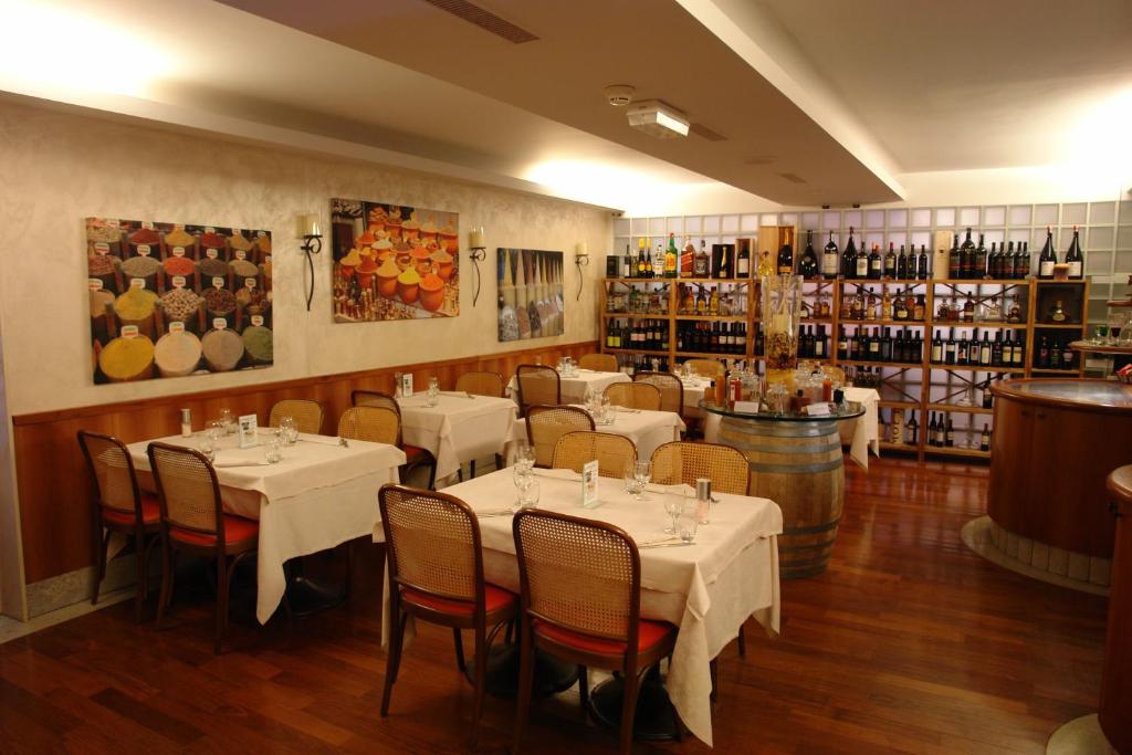 a restaurant with tables and chairs in a room at Hotel Bahnhof Haus in Chiasso