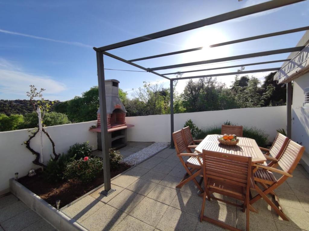 a patio with a table and chairs and an outdoor oven at Holiday Home Ivo in Sevid