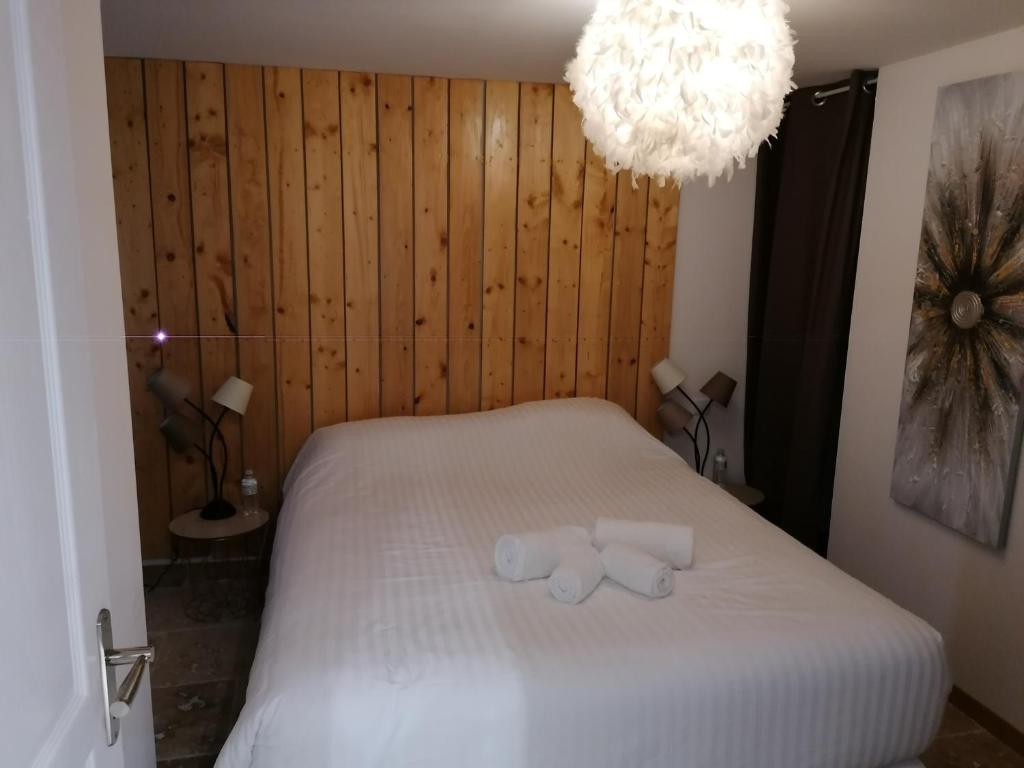 a bedroom with a bed with two towels on it at Appartement PERIGUEUX Garage Fibre Climatisation in Périgueux