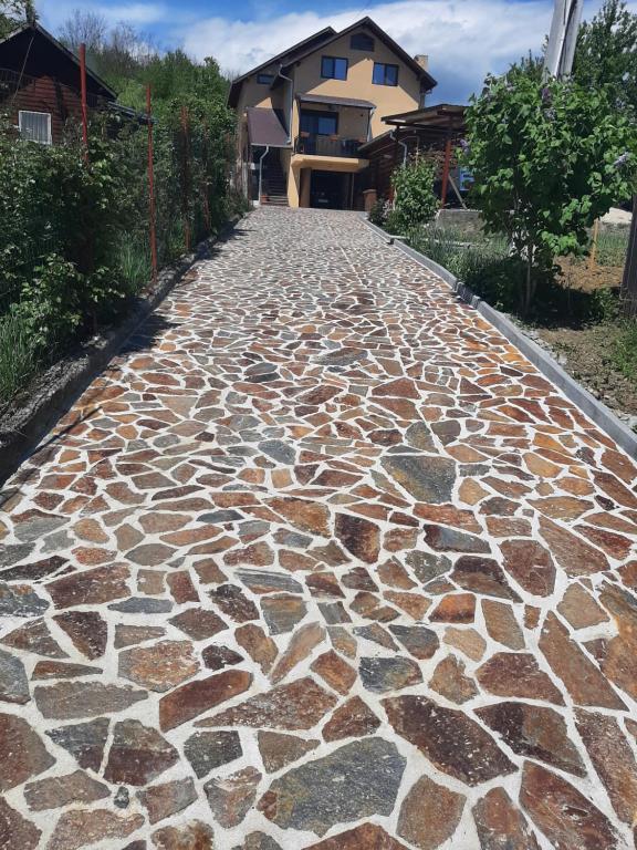 a cobblestone walkway with rocks on it in front of a house at Casa Edy in Călimăneşti