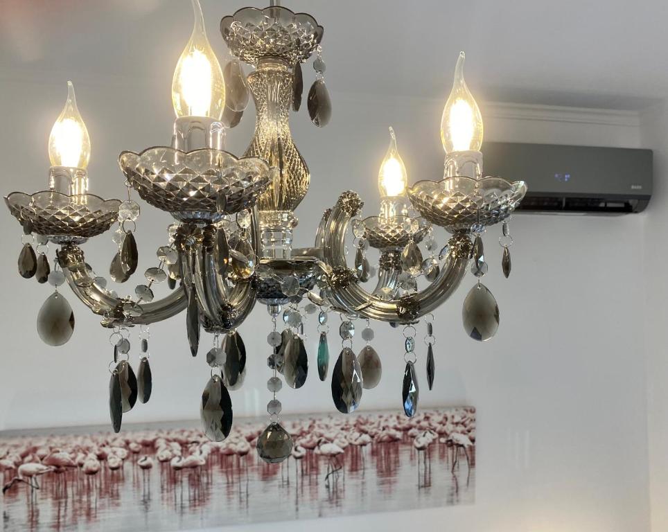 a chandelier with three lights and feathers on a table at PORTA HOME modern and hospitable in Naxos Chora