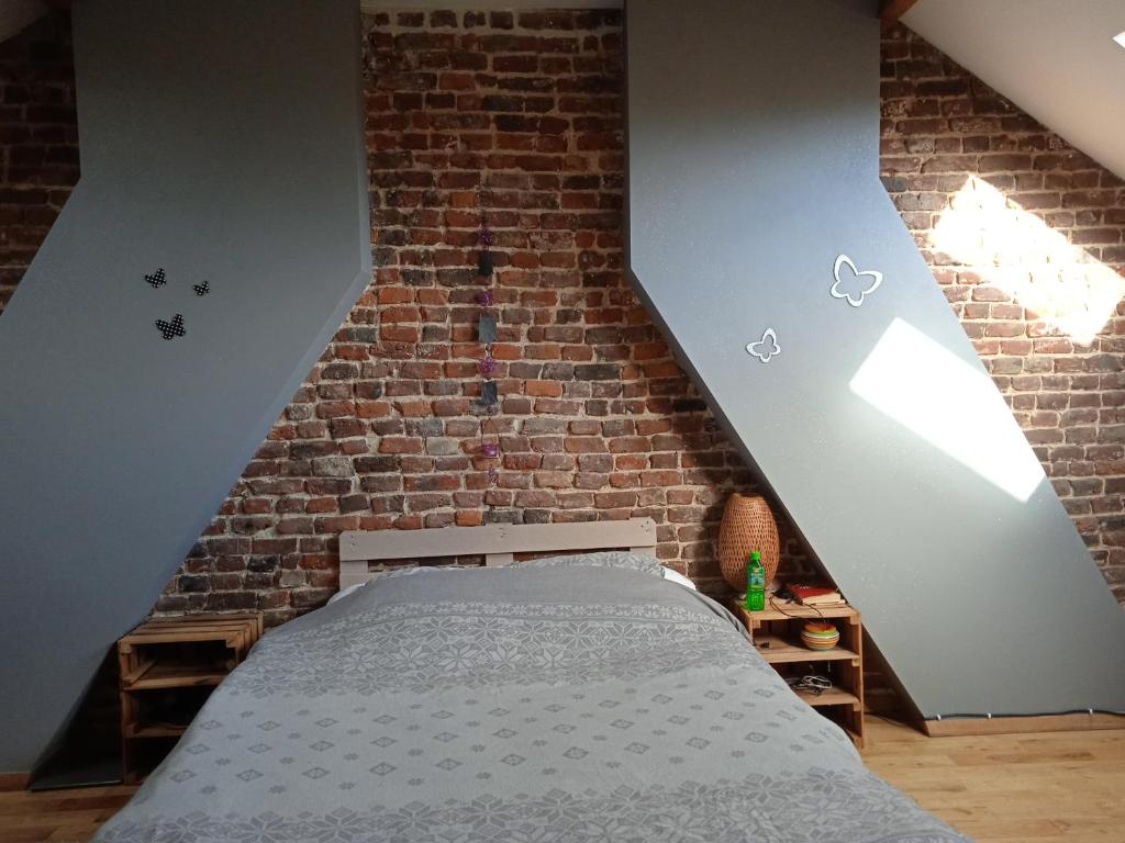 een slaapkamer met een bed in een bakstenen muur bij Sweet home 2 in Charleroi