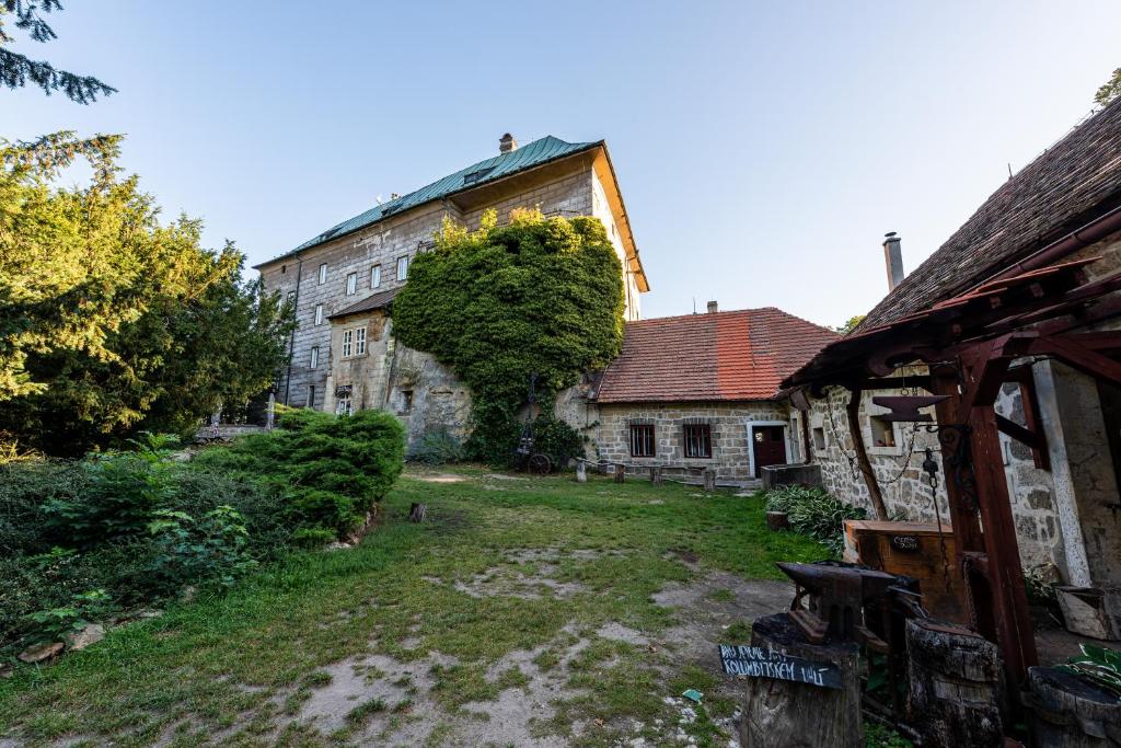um edifício antigo com um quintal em frente em Hájovna hradu Houska em Doksy