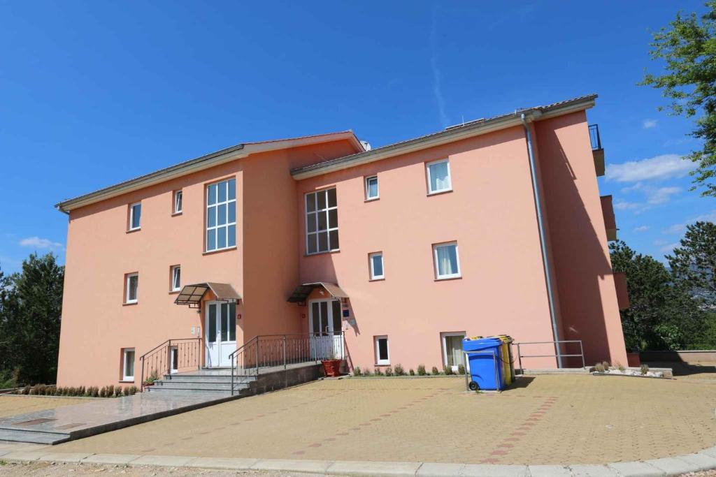 a large pink building with a blue trash can in front at Apartment in Silo/Insel Krk 13582 in Šilo