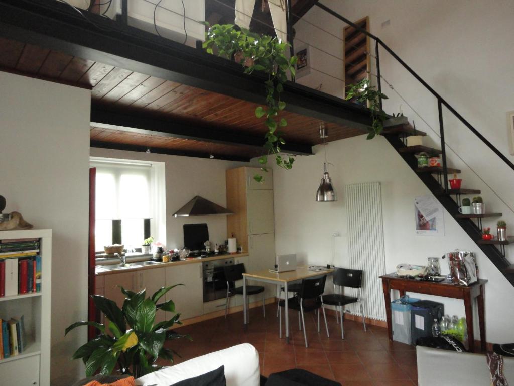 sala de estar con escalera y mesa con sillas en Monolocale Suvereto, en Suvereto