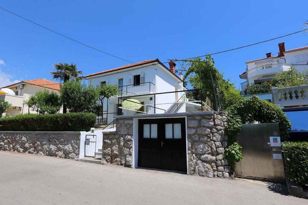 a house with a stone wall and a door at Apartment in Silo/Insel Krk 13550 in Šilo