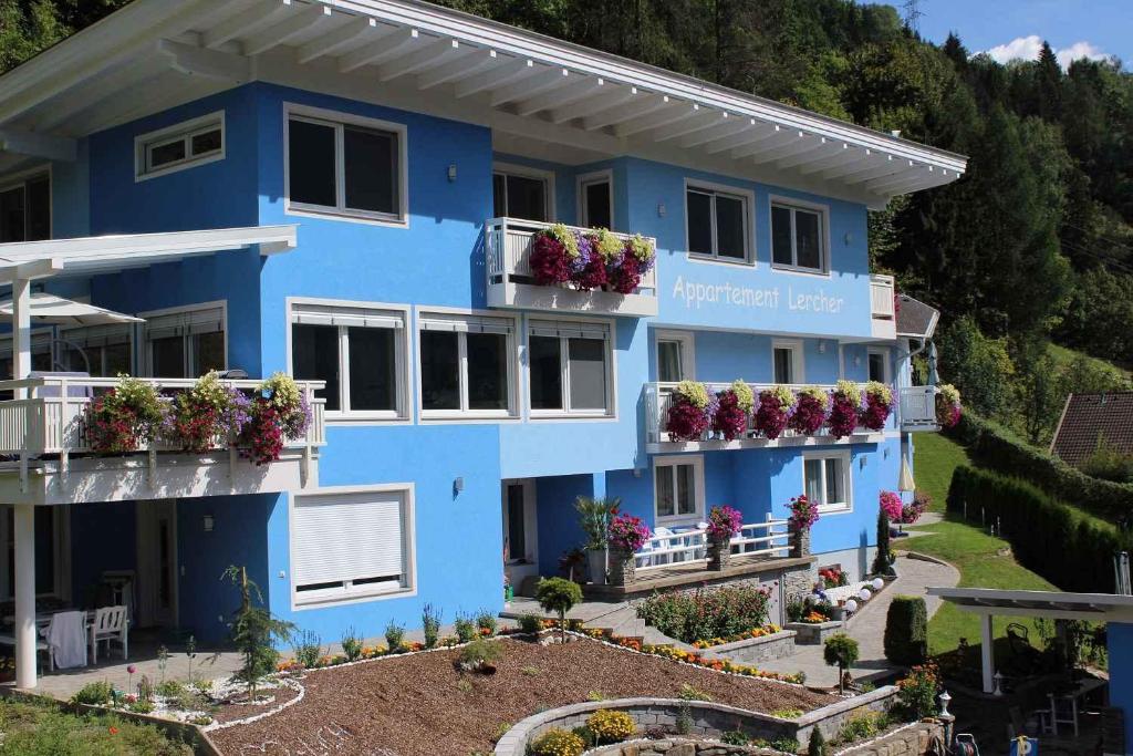 a blue building with flowers on the balconies at Flattach Apartment 3 in Ausserfragant