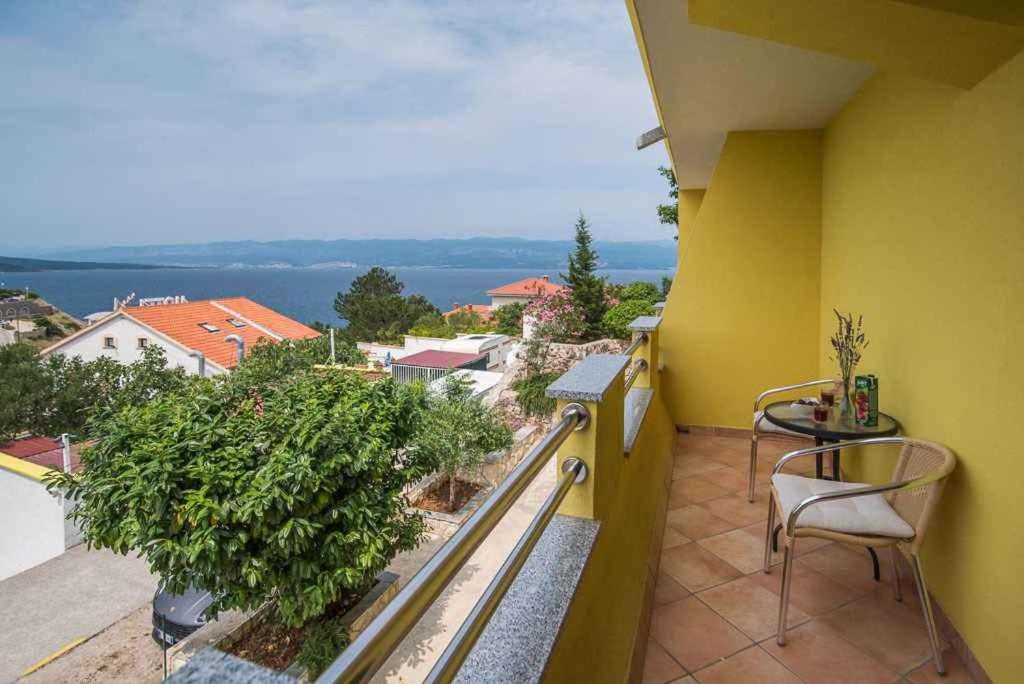 a yellow balcony with a view of the water at Apartment Vrbnik 21 in Vrbnik