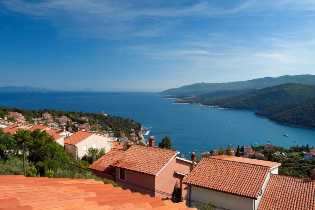 a town with a view of the water and houses at Apartment in Rabac 16817 in Rabac