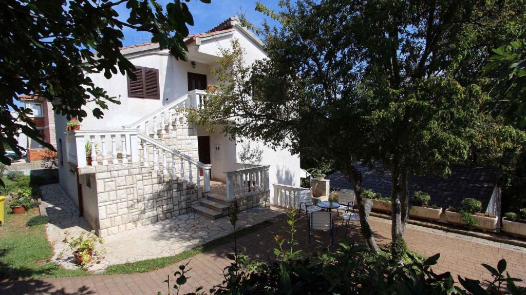 a white house with stairs and a tree at Apartment Porat 1 in Porat