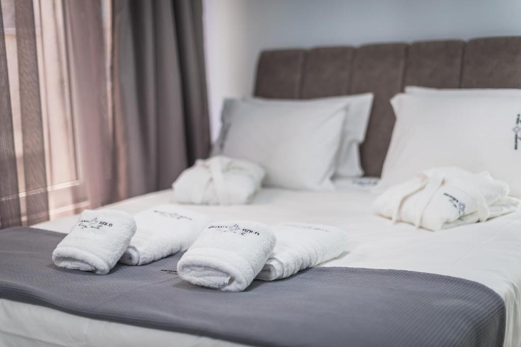 un lit avec des serviettes blanches dessus dans l'établissement Iguana Gold Luxury Suites 1min from Ermou str, à Athènes