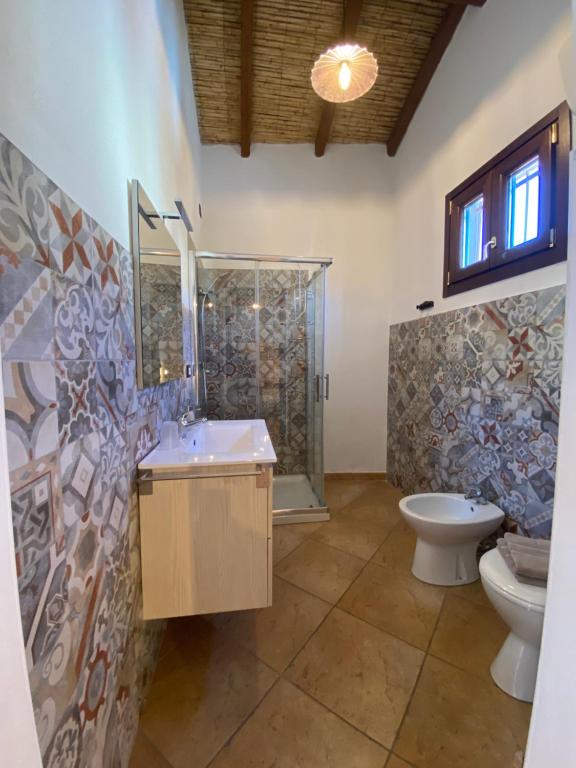 a bathroom with a shower and a sink and a toilet at Centu Concas in Muravera