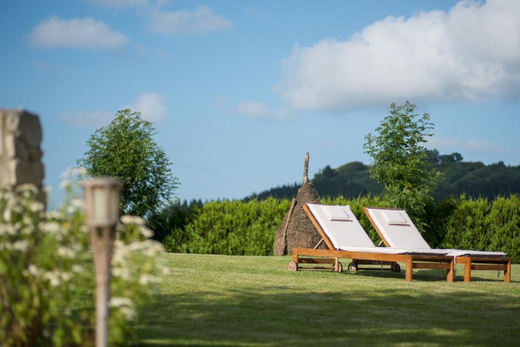 a group of lounge chairs sitting on a grass field at Casa Rural-Apartamentos Zelaikoa in Zestoa