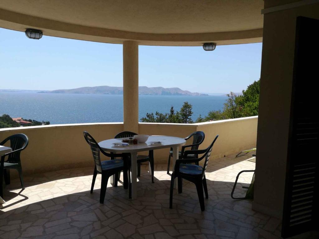 Una mesa y sillas en un balcón con vista al agua. en Apartment Sv. Juraj 3, en Turine