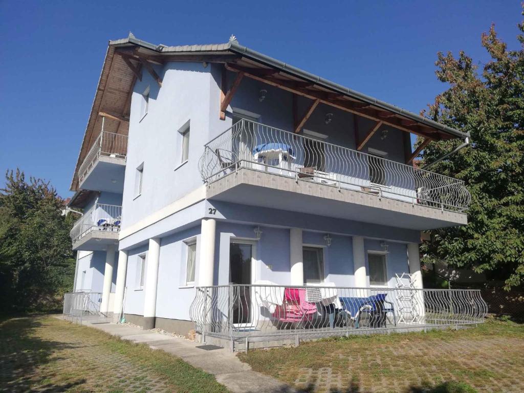 a large white building with a balcony and chairs at Apartment Zalakaros 8 in Zalakaros