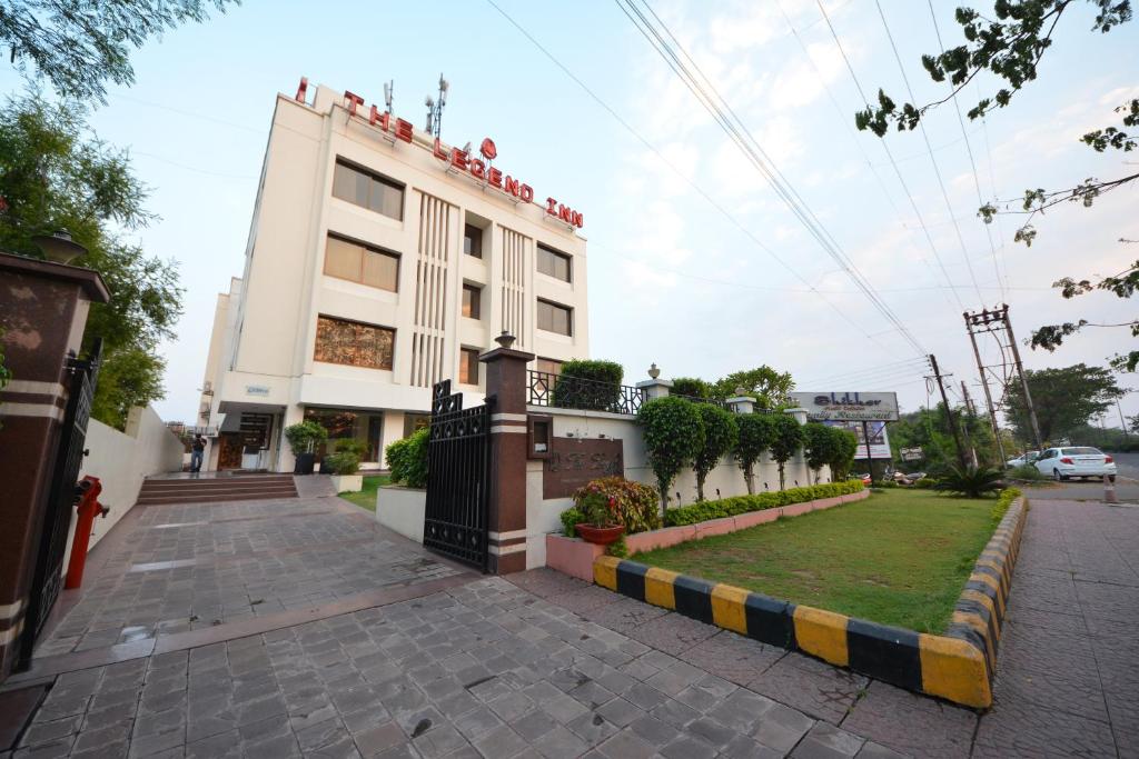 ein weißes Gebäude mit einem Rasen davor in der Unterkunft The Legend Inn @Nagpur in Nagpur