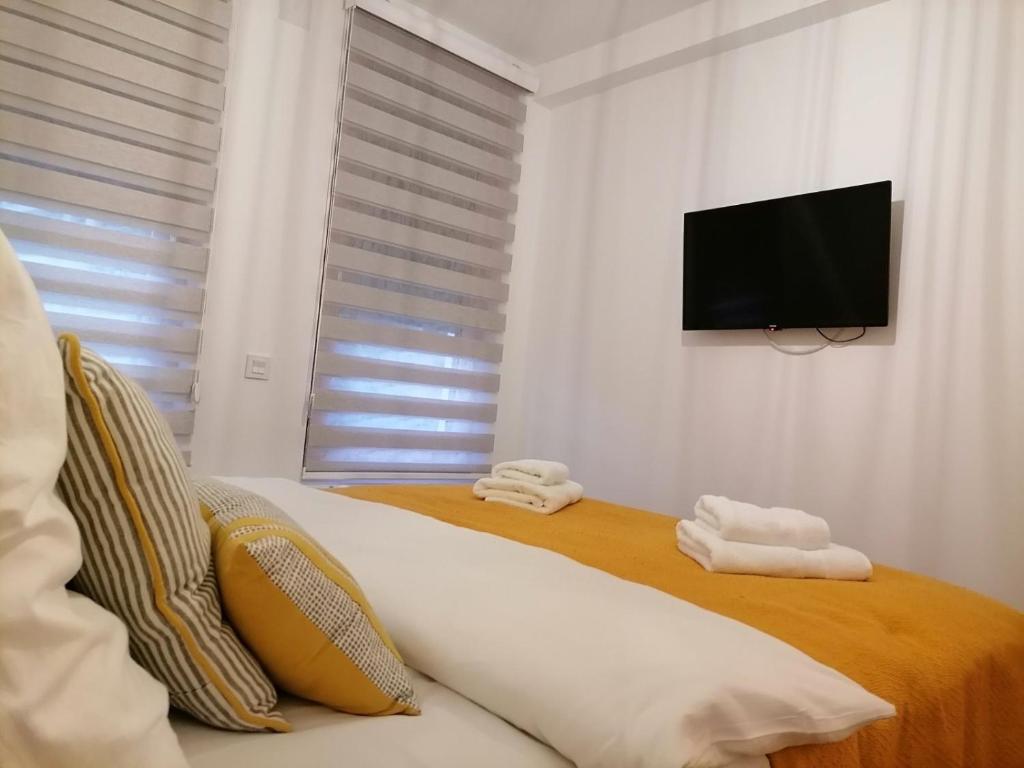 a bedroom with a bed with towels and a flat screen tv at La Siesta Apartment in Zlatibor